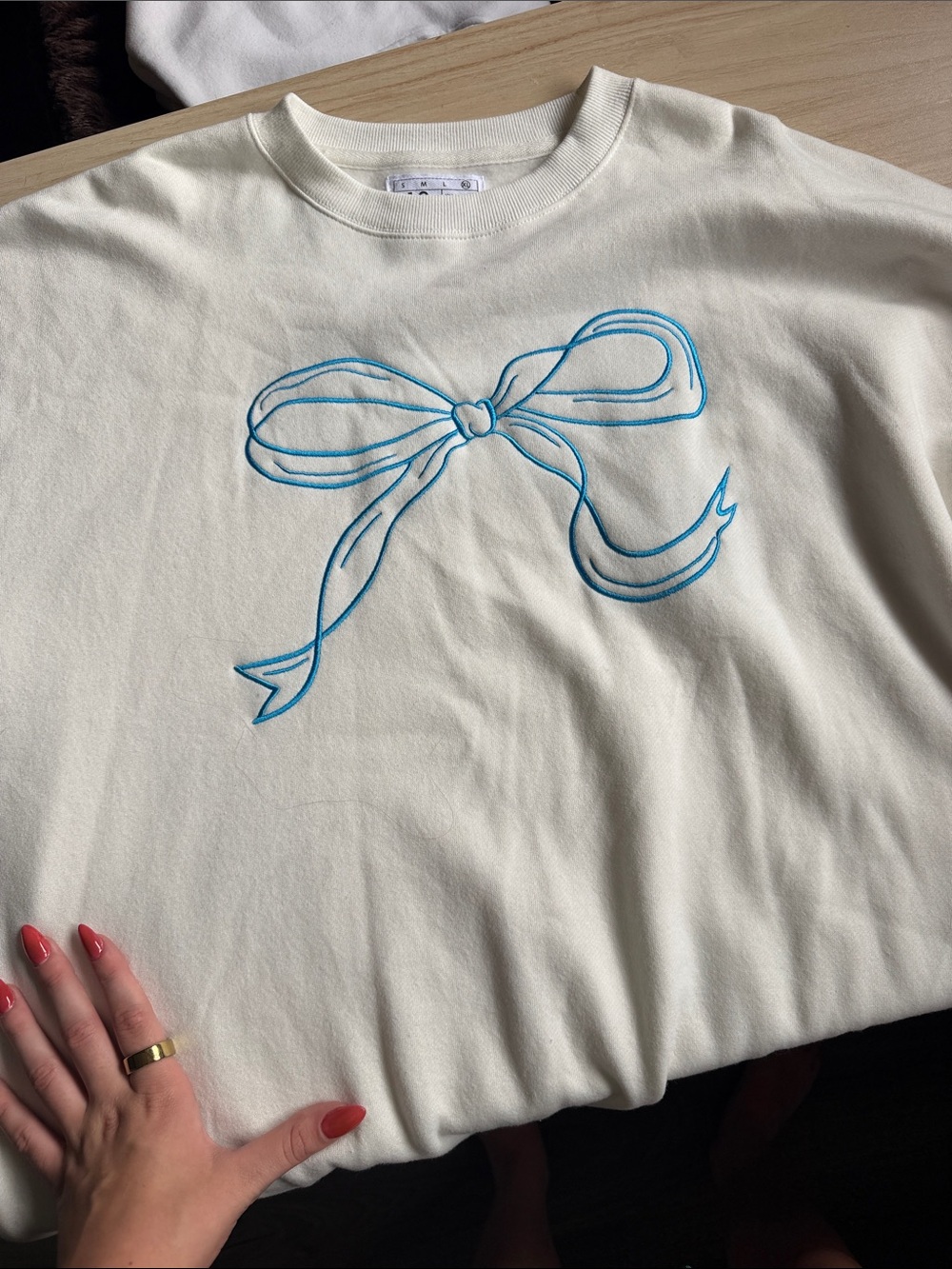 Cream Crewneck Top with Blue Bow Illustration